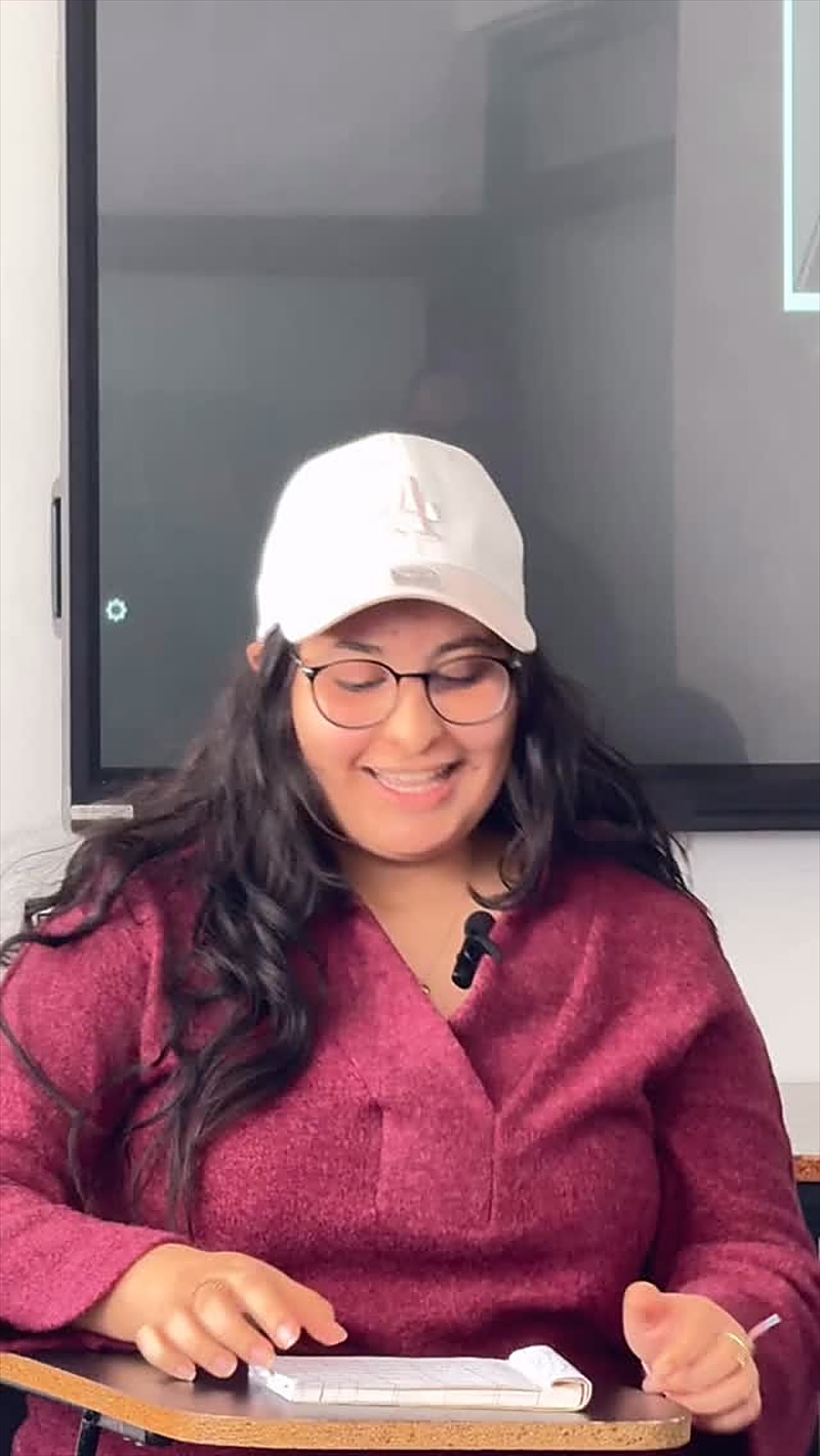 Une étudiante souriante pendant le cours