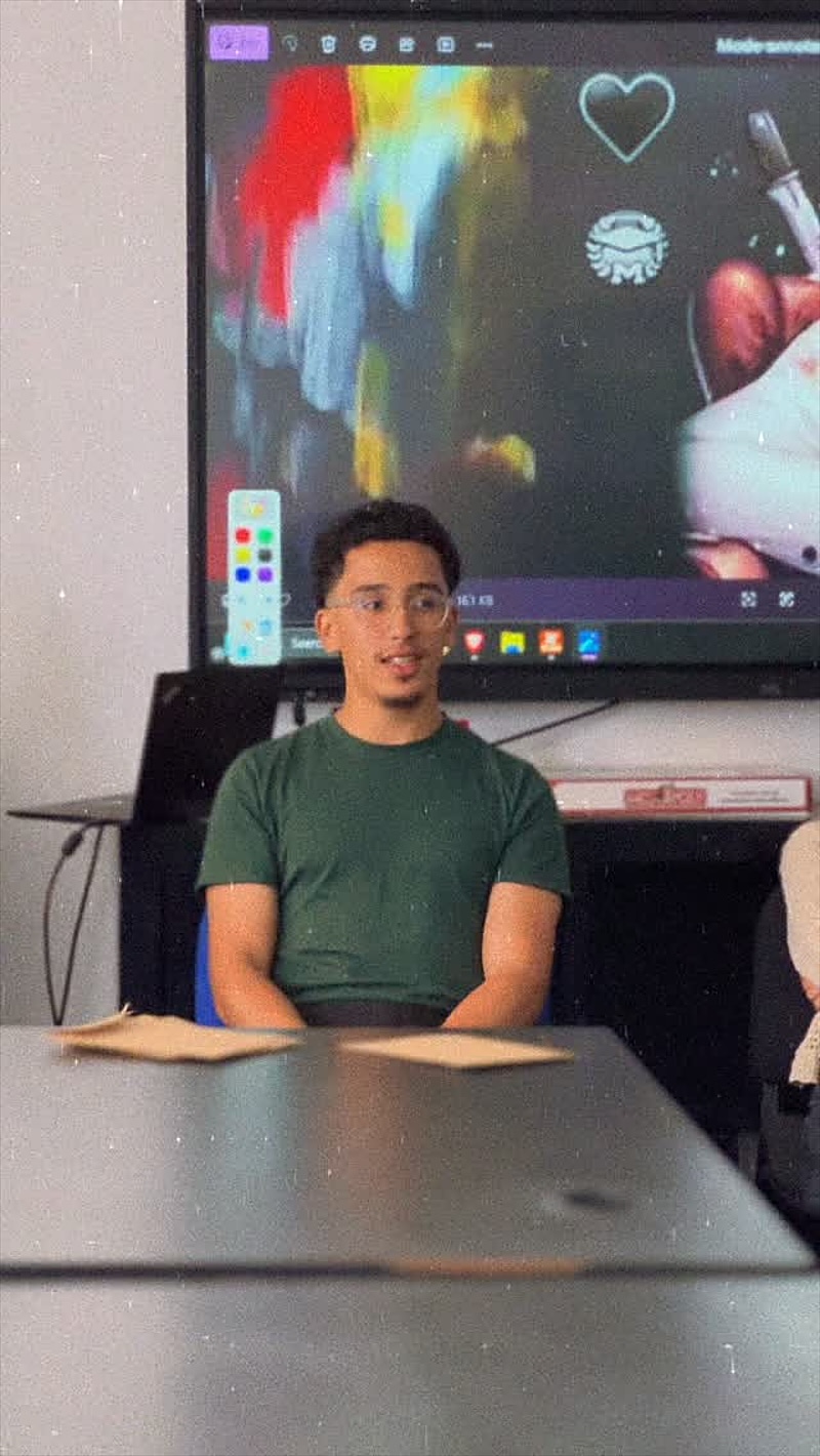 Un étudiant à la table du TalkLab, devant l’écran interactif