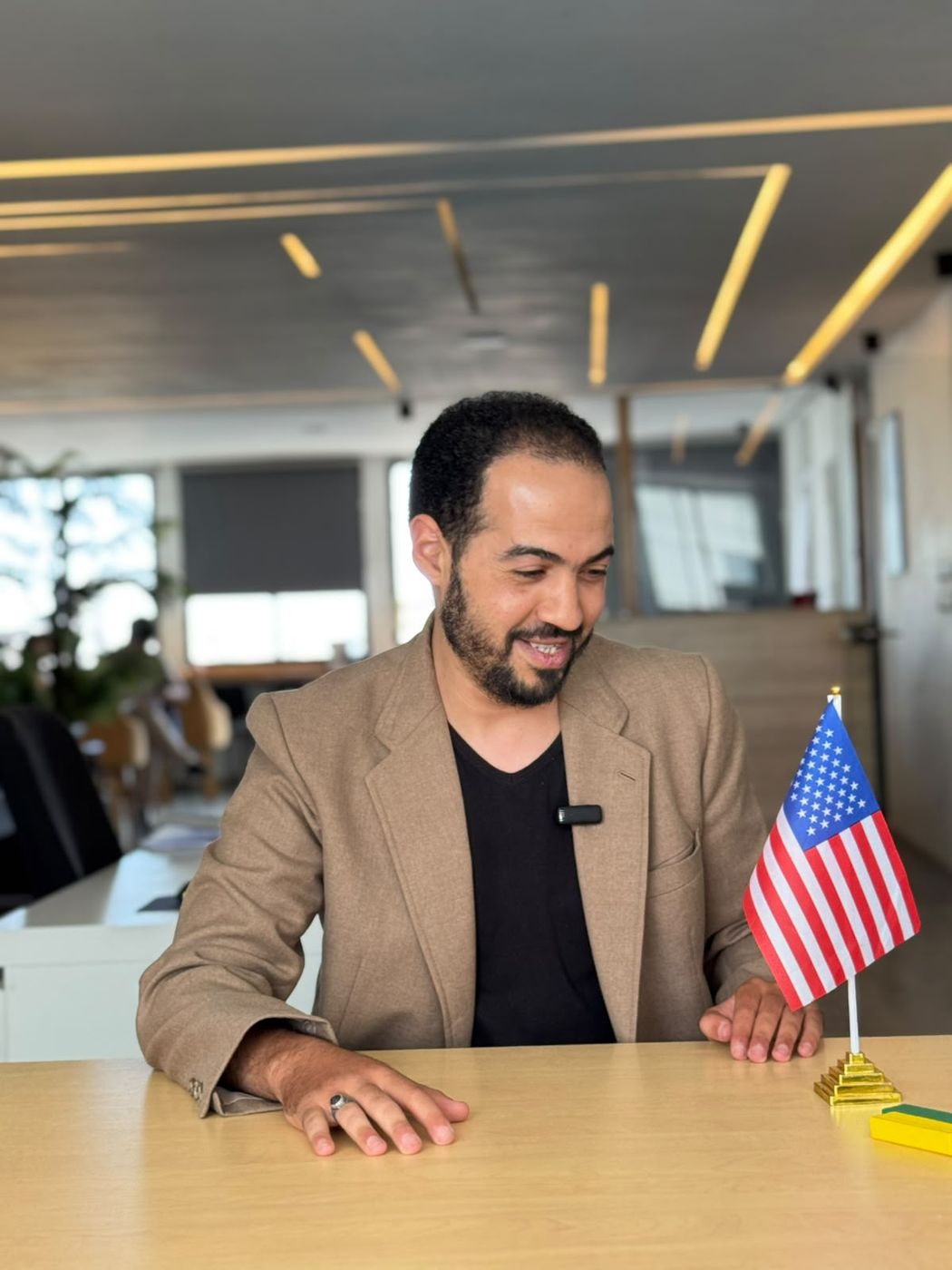 Un professeur d’anglais à son bureau, à côté du drapeau américain