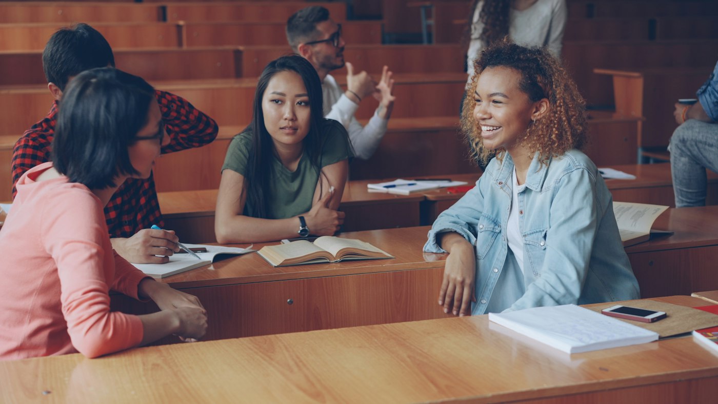 Des étudiants souriants échangent pendant un cours